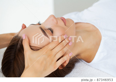 Beautiful girl has a facial massage in a beauty clinic. Beautiful girl has a facial massage in a beauty clinic. 87346953