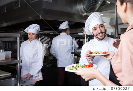 Chef with team preparing food Chef with team preparing food 87350027