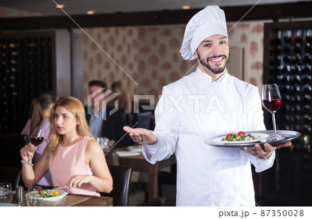 chef with dishes on serving tray welcoming 87350028