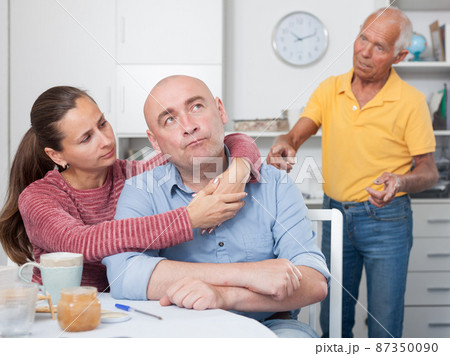 Couple hugging after conflict, worried elderly man on backgroud 87350090