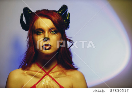 Beautiful young woman with makeup zodiac signs of Capricorn or Aries or Taurus. Girl with horns on head. 87350517
