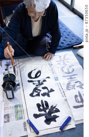 自宅で習字の練習をする女性 87350650