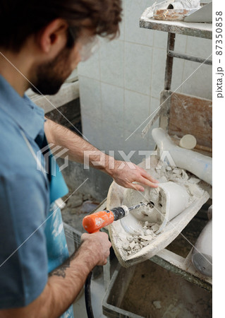 Above angle of young worker of prosthetic factory drilling plaster cast Above angle of young worker of prosthetic factory drilling plaster cast 87350858