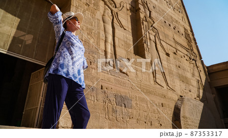 Beautiful woman tourist in Philae Temple Complex. Temple Of Isis. Philae, Agilkia Island, Aswan, Egypt Beautiful woman tourist in Philae Temple Complex. Temple Of Isis. Philae, Agilkia Island, Aswan, Egypt 87353317
