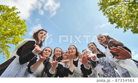 Happy Russian graduates send an airy kiss. 87354563