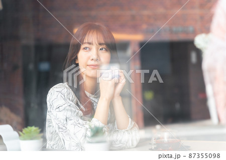 窓越しに見えているカフェの若い女性 87355098