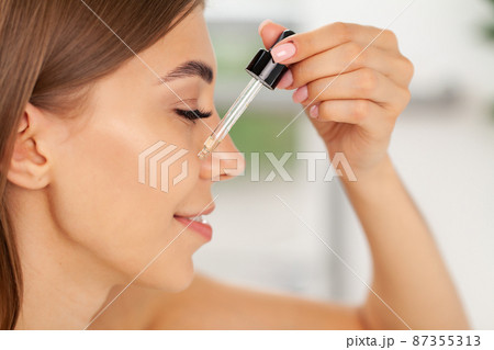 Beautiful woman fresh healthy skin looking on mirror makes makeup 87355313