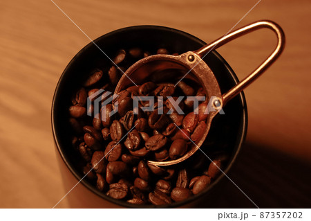 計量スプーンとキャニスターの中のコーヒー豆 計量スプーンとキャニスターの中のコーヒー豆 87357202