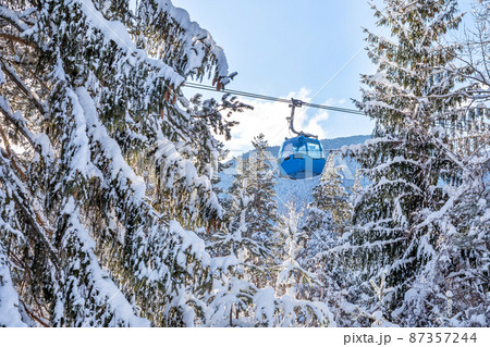 Ski resort, gondola ski lift cabin and pine trees Ski resort, gondola ski lift cabin and pine trees 87357244