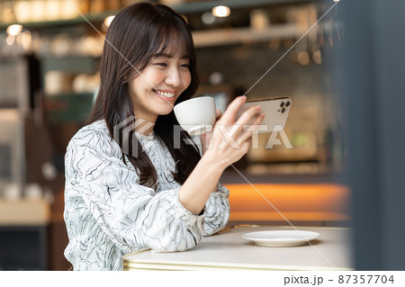 カフェで動画を観ている若い女性 カフェで動画を観ている若い女性 87357704