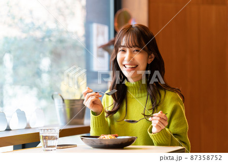 カフェでパスタを食べている若い女性 カフェでパスタを食べている若い女性 87358752