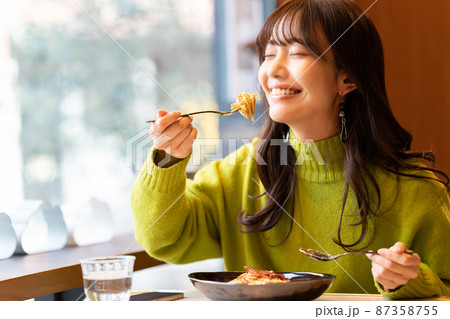 カフェでパスタを食べている若い女性 87358755