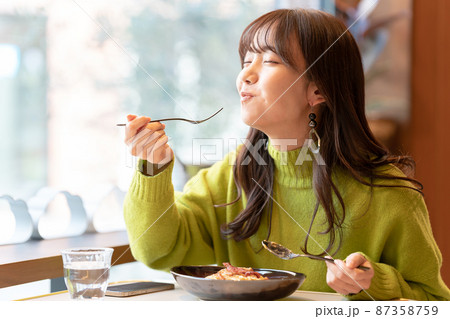カフェでパスタを食べている若い女性 カフェでパスタを食べている若い女性 87358759