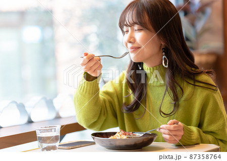 カフェでパスタを食べている若い女性 カフェでパスタを食べている若い女性 87358764