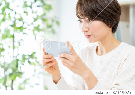スマホを見るミドル女性 87359025
