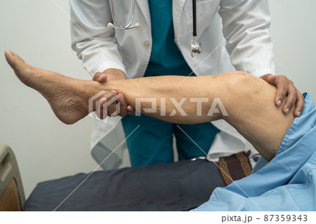 Asian doctor physiotherapist examining, massaging and treatment knee and leg of senior patient in orthopedist medical clinic nurse hospital. Asian doctor physiotherapist examining, massaging and treatment knee and leg of senior patient in orthopedist medical clinic nurse hospital. 87359343