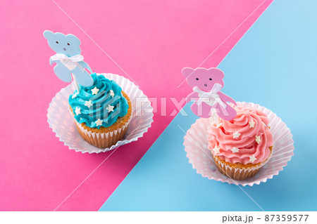 Pink and blue cupcakes for baby shower on pink and blue background Pink and blue cupcakes for baby shower on pink and blue background 87359577