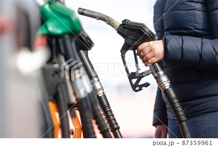 High prices of petrol and diesel fuel ath the petrol station, young woman refueling the car, economic crisis concept 87359961