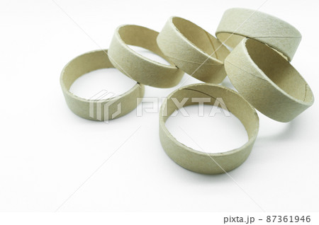 Narrow cardboard spools for winding rolled materials and self-adhesive labels. Reels made of cardboard for printing houses. Selective focus, isolated on white Narrow cardboard spools for winding rolled materials and self-adhesive labels. Reels made of cardboard for printing houses. Selective focus, isolated on white 87361946