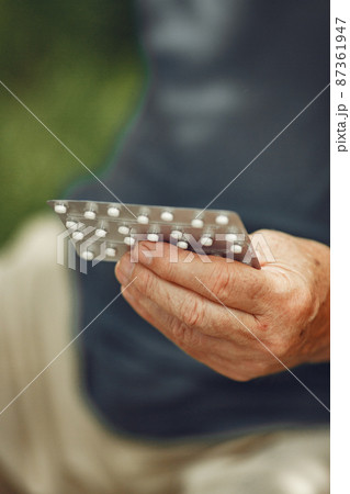 Portrait of helderly man holding pills Portrait of helderly man holding pills 87361947