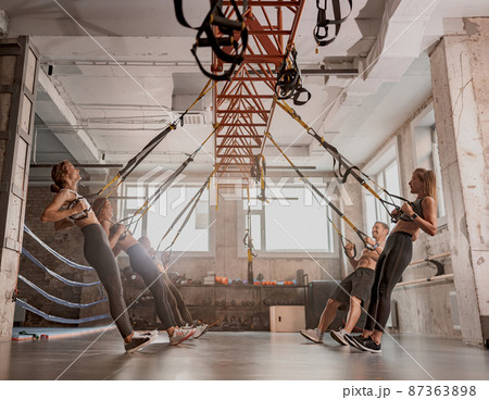 Athletic people doing crossfit training in gym 87363898