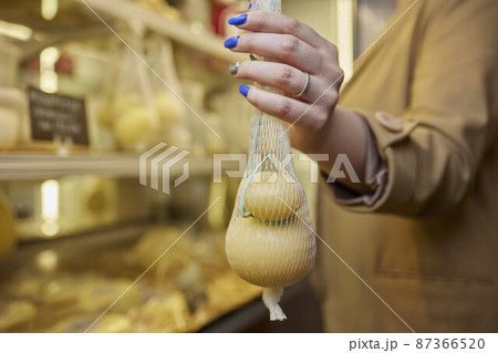 Delicious fresh Caciocavallo and Scamorza cheese hanging. Italian cheeses close up. The cheeses are handmade. The production of cheese. Delicious fresh Caciocavallo and Scamorza cheese hanging. Italian cheeses close up. The cheeses are handmade. The production of cheese. 87366520