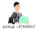 藍染の浴衣を着てうちわを持つ女性 87366917