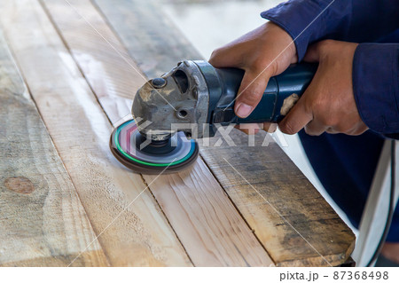 Carpenter polishing pinewood with sander machine Carpenter polishing pinewood with sander machine 87368498