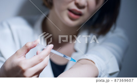 注射を打つ女性（薬物中毒・薬物依存症・ドラッグ） 87369607