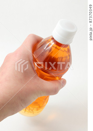 飲料水,飲み物,茶色,ペットボトル,飲物,ドリンク,水分、手,皮膚,人,指,ボディパーツ、パーツ 87370349