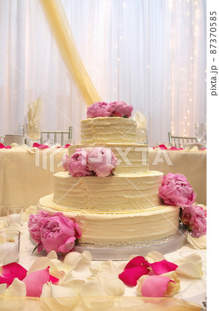 An Elegant Tiered Buttercream Wedding Cake Decorated with Peonies An Elegant Tiered Buttercream Wedding Cake Decorated with Peonies 87370585