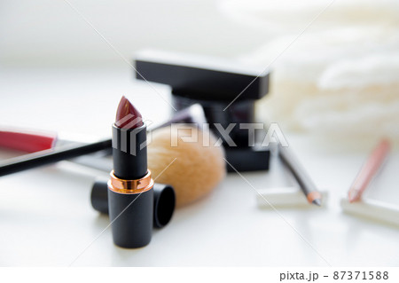 Two pencils for eyes and lips, lipstick, brushes, blush lie together on white background. High quality photo 87371588