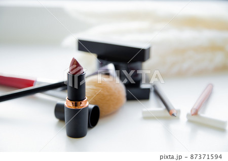 Two pencils for eyes and lips, lipstick, brushes, blush lie together on white background. High quality photo 87371594