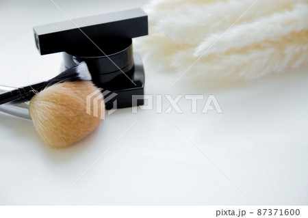 Lipstick, brushes and blush lie together next to fluffy branch of a cane on a white background. High quality photo Lipstick, brushes and blush lie together next to fluffy branch of a cane on a white background. High quality photo 87371600