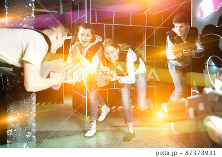 Girl with friends playing laser tag Girl with friends playing laser tag 87373931