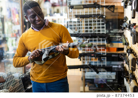 African american man in army uniform with weapon in market African american man in army uniform with weapon in market 87374453