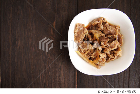 木製のテーブルの上にある白い四角い皿に入った牛皿 87374930