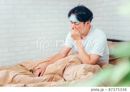 風邪をひいてベッドで寝る男性 風邪をひいてベッドで寝る男性 87375336