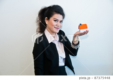 Business woman hold house toy model on white background 87375448