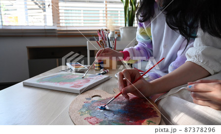 Two girl enjoy painting pictures with watercolor while spending weekend at home together. Two girl enjoy painting pictures with watercolor while spending weekend at home together. 87378296