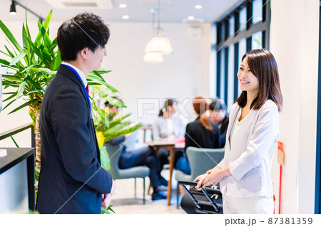 フロントでホテルのチェックインをする若いビジネスウーマン フロントでホテルのチェックインをする若いビジネスウーマン 87381359