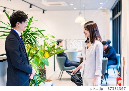 フロントでホテルのチェックインをする若いビジネスウーマン フロントでホテルのチェックインをする若いビジネスウーマン 87381367