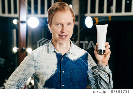hairdresser and stylist barbershop worker with with tube of hair care products hairdresser and stylist barbershop worker with with tube of hair care products 87381751