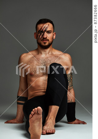 Animal instinct fitness instructor sportsman showing his incredible flexibility with an animal flow move in studio against a gray background 87382666