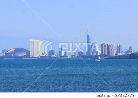能古島の浜辺から見た福岡市街と海を疾走するヨット 能古島の浜辺から見た福岡市街と海を疾走するヨット 87382778