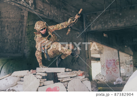 A bearded soldier in uniform of special forces in a dangerous military action in a dangerous enemy area. Selective focus A bearded soldier in uniform of special forces in a dangerous military action in a dangerous enemy area. Selective focus 87382904