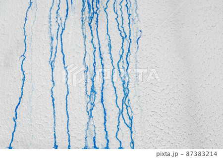 Streaks of liquid spilled blue paint down the white plaster wall abstract pattern dirty background design Streaks of liquid spilled blue paint down the white plaster wall abstract pattern dirty background design 87383214