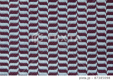 Knitted texture. Texture of jacquard fabric with gray blue geometric pattern. Crochet mosaic pattern. Knitted texture. Texture of jacquard fabric with gray blue geometric pattern. Crochet mosaic pattern. 87385098