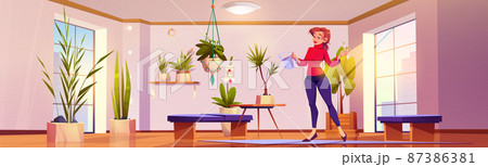 Woman waters plants and flowers at home 87386381