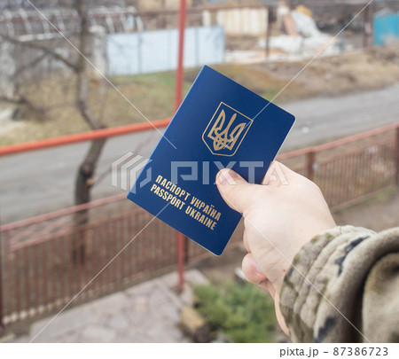 Concept. A Ukrainian soldier in camouflage is holding a Ukrainian passport with the symbols of the country. Homeland defense. The work of border control and the army of Ukraine. Mobilization Concept. A Ukrainian soldier in camouflage is holding a Ukrainian passport with the symbols of the country. Homeland defense. The work of border control and the army of Ukraine. Mobilization 87386723